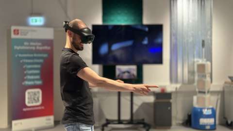 Ein Mann trägt eine Virtual Reality-Brille während er sich durch einen Raum bewegt.
