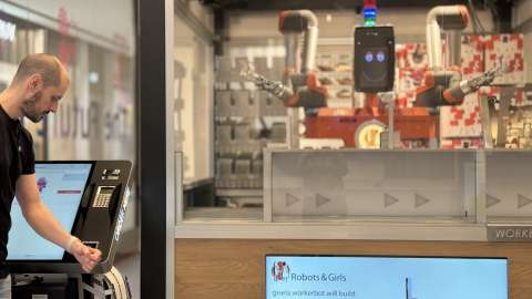 Mann bezahlt am vollautomatischen Roboter-Kiosk
