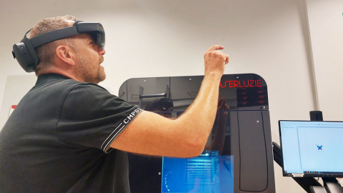 Das Bild zeigt eine Person mit einer AR-Brille, die eine Laserbeschriftungsanlage bedient.