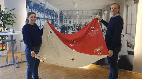 Zwei Personen halten das Kooperationsspiel in der Hand