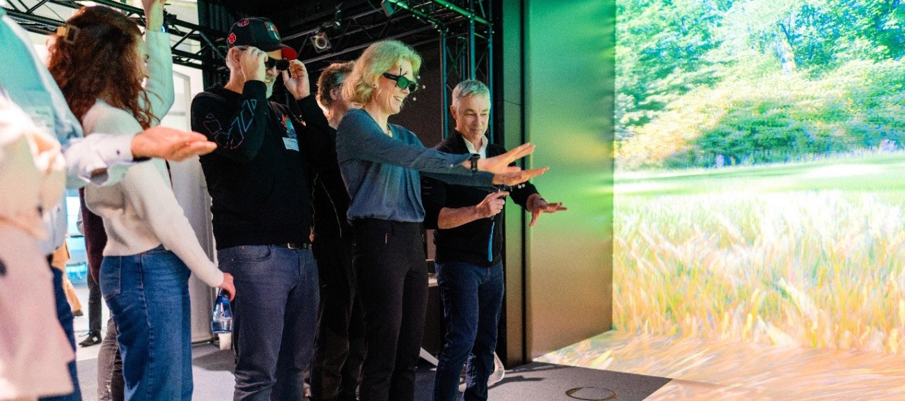 Besucher:innen probieren die VR-Anwendung EX CAVE aus.