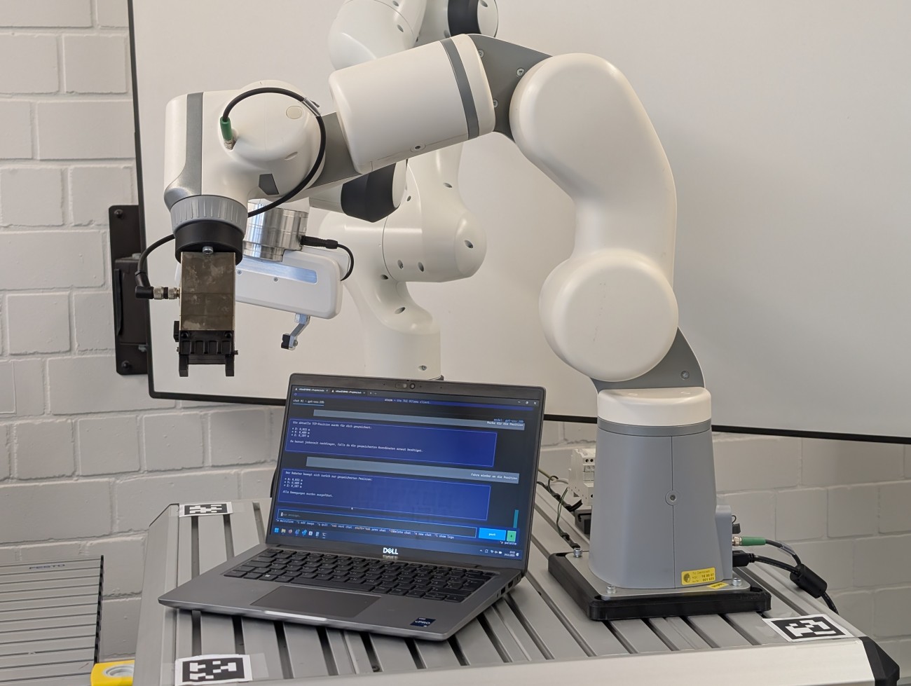 Bild eines Demonstrators mit Roboterarm, der über eine Chatsteuerung ansteuerbar ist.