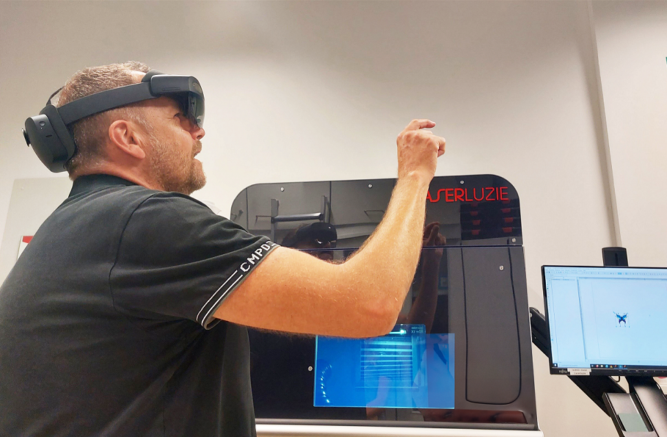 Das Bild zeigt eine Person mit einer AR-Brille, die eine Laserbeschriftungsanlage bedient.